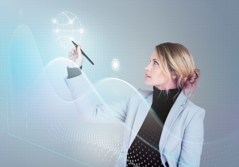 Mercado de trabalho para gerentes de projetos e o impacto da transformação digital Mulher usando caneta digital para interagir com gráfico holográfico, simbolizando inovação e tecnologia no mercado de trabalho para gerentes de projetos.