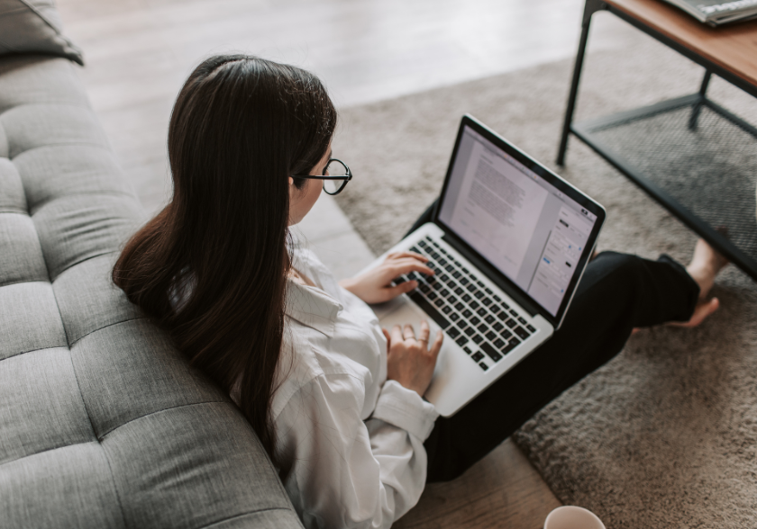 Pessoa estudando com livros e materiais de escritório sobre a mesa, simbolizando o aprendizado contínuo em casa.